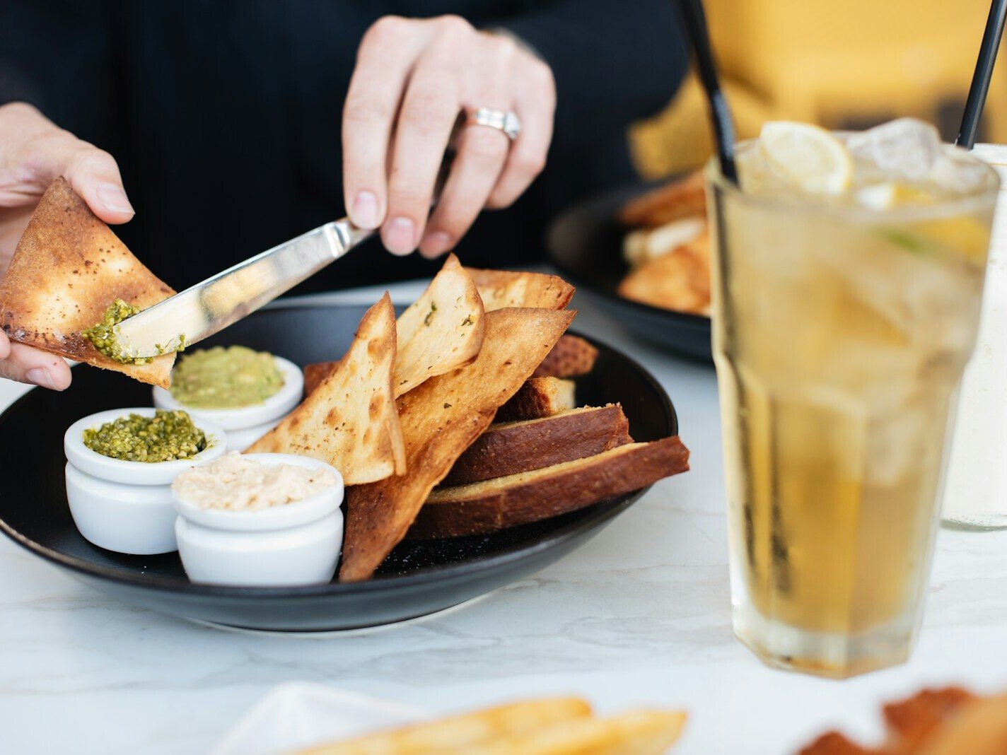 person putting spread on toasted bread